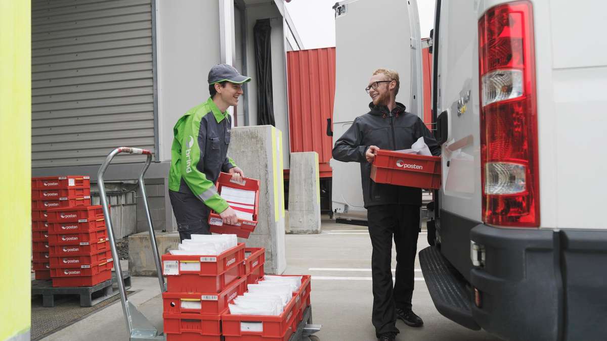 Two men loading a truck with mail