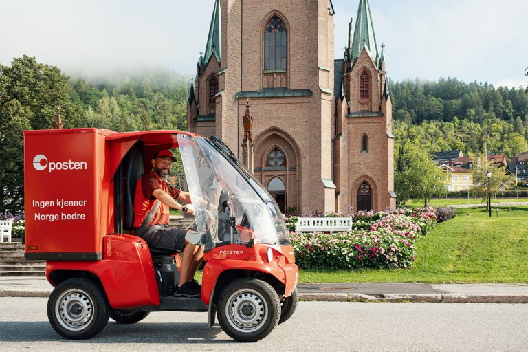 Paxter fra Posten kjører foran en kirke