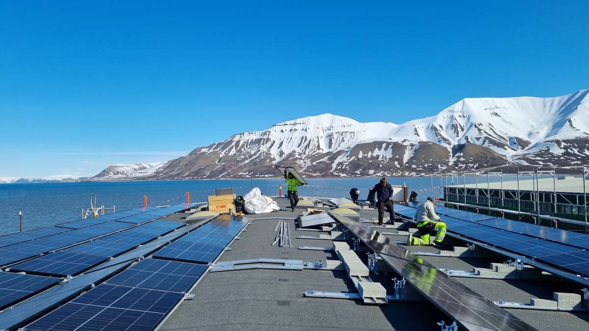 Flere personer som monterer solceller på et tak.