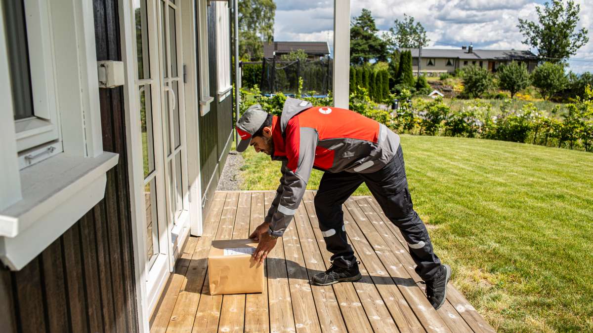 Postbud setter pakken utenfor døren.